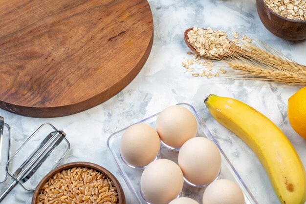 Top view of wooden round board and ingredients for the healthy food set on stained white background