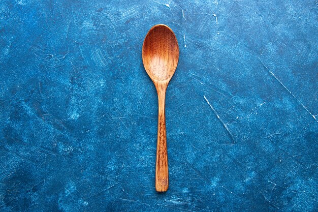 Top view wooden spoon on blue table copy place