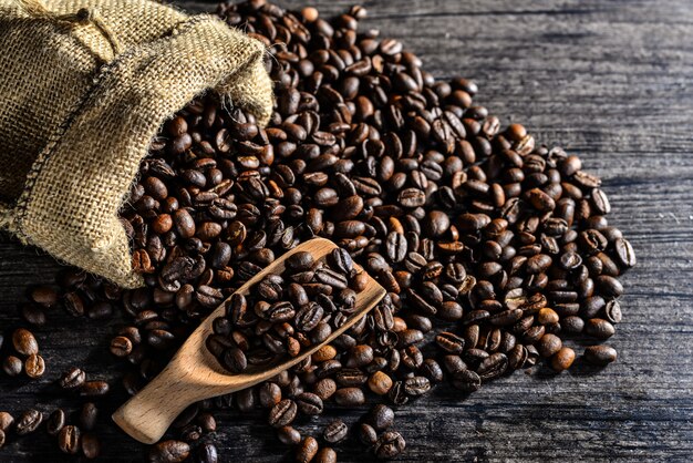 Top view of wooden spoon and a canvas bag of coffee beans