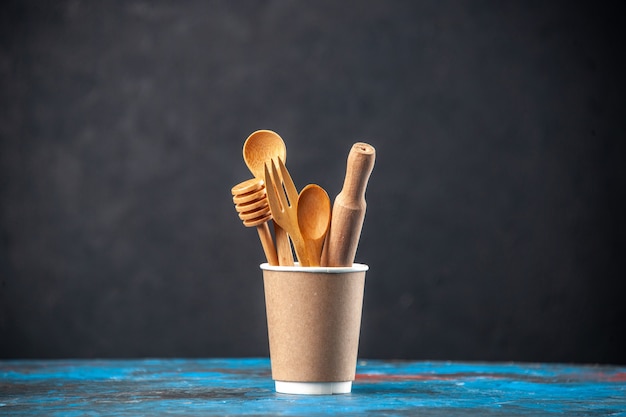 Free photo top view of wooden spoons in an empty plastic coffee pot on blue surface