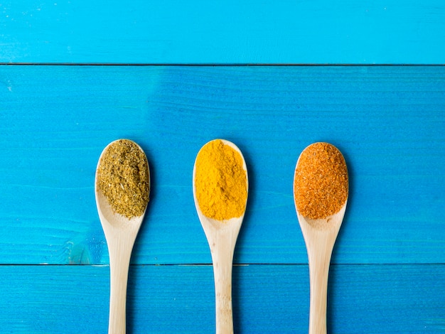 Top view wooden spoons full of spices