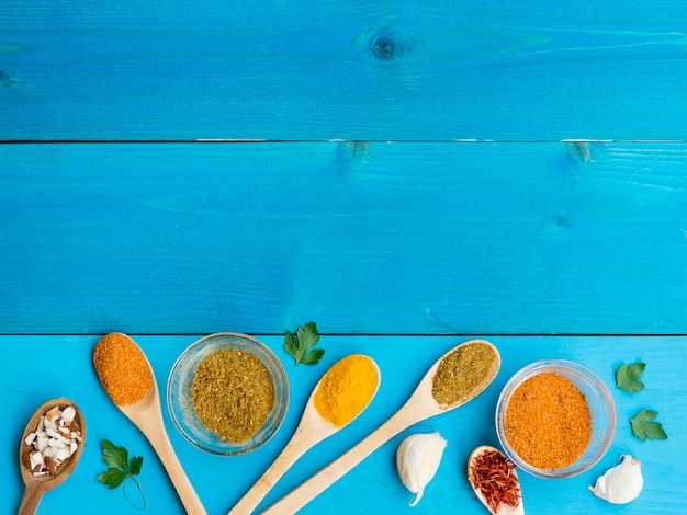 Free photo top view wooden spoons full of spices