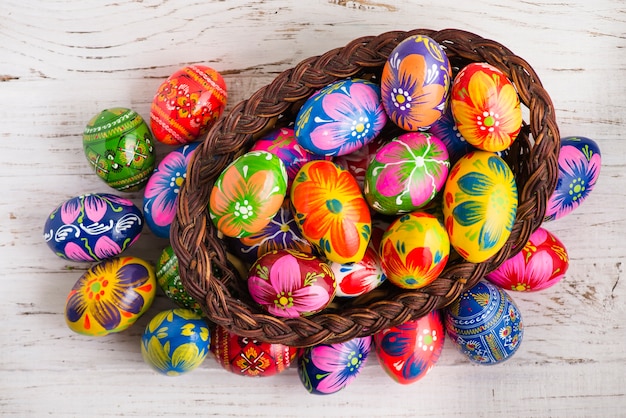 Top view of wooden surface with basket and easter eggs