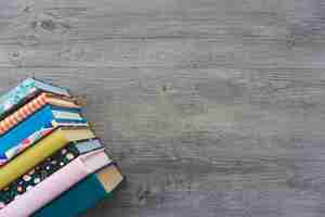 Free photo top view of wooden surface with books and blank space