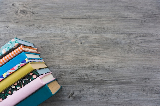 Top view of wooden surface with books and blank space