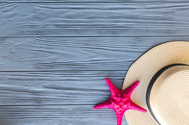 Top view of wooden surface with starfish and hat