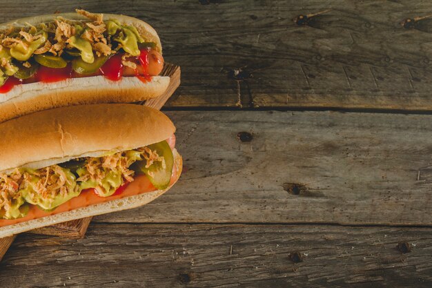 Top view of wooden surface with two appetizing hot dogs