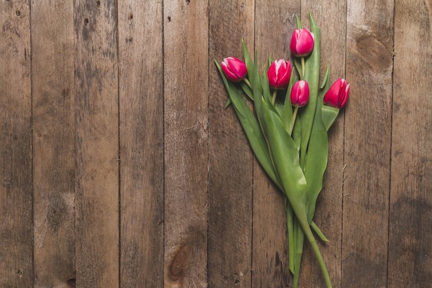 Top view of wooden table with cute tulips