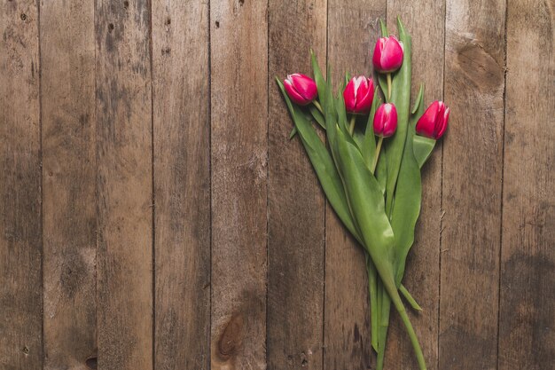 Top view of wooden table with cute tulips