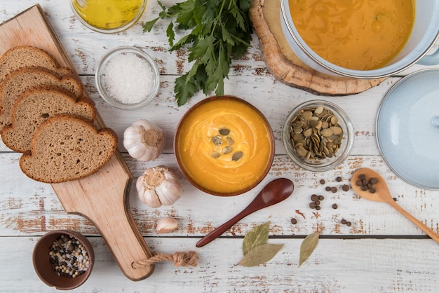 Top view wooden table with soup and slices of bread