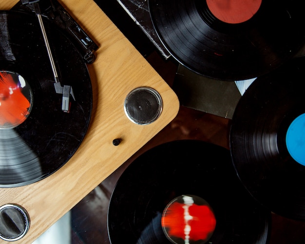 Top view of wooden turntable and vinyl records