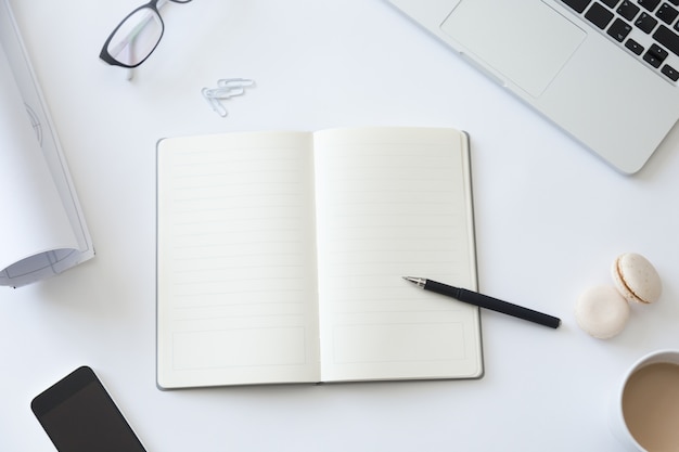 Top view of a working desk with notebook and whatman