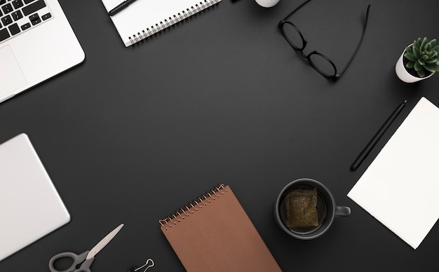 Top view of workspace with glasses and cup of tea