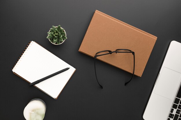 Top view of workspace with glasses and laptop