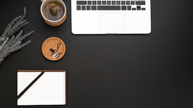 Top view of workspace with laptop and cup of tea