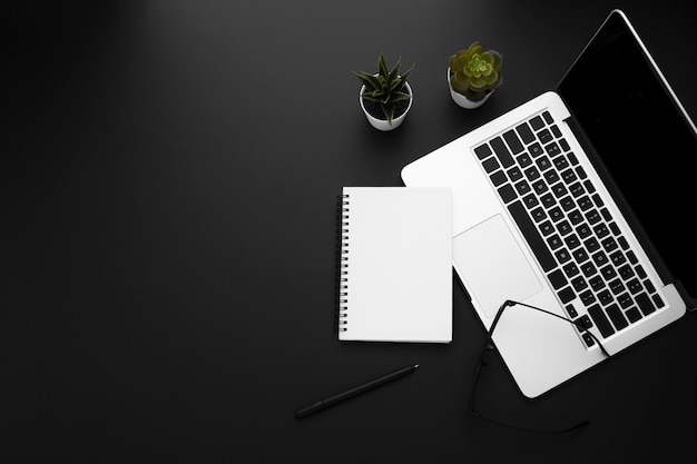 Top view of workspace with laptop and notebook