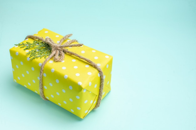 Top view of xmas background with yellow gift box on pastel green background