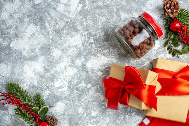 Top view xmas gifts cereal in jar xmas tree branches on grey table copy space