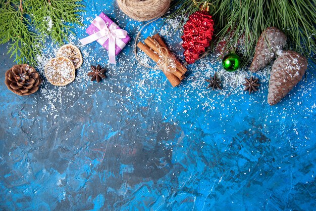 Top view xmas gifts fir tree branches cones anises on blue background