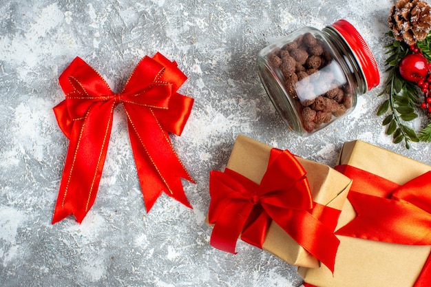 Top view xmas gifts red bow cereal in jar on grey table