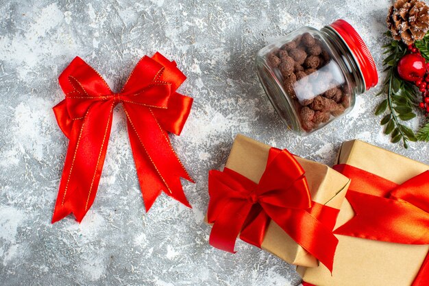 Top view xmas gifts red bow cereal in jar on grey table