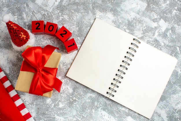 Top view xmas gifts santa hat wooden blocks notebook on grey white table