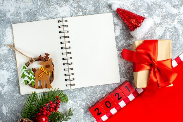 Top view xmas ornament on notebook wood blocks small santa hat on grey white table