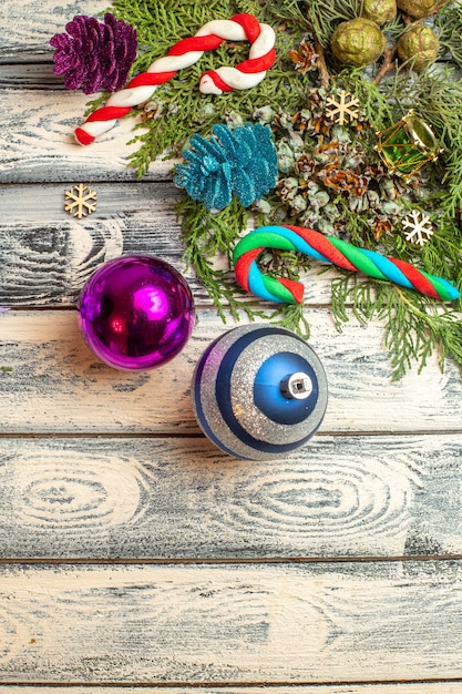 Вид сверху рождественские украшения подарки конфеты еловые ветки на деревянной поверхности