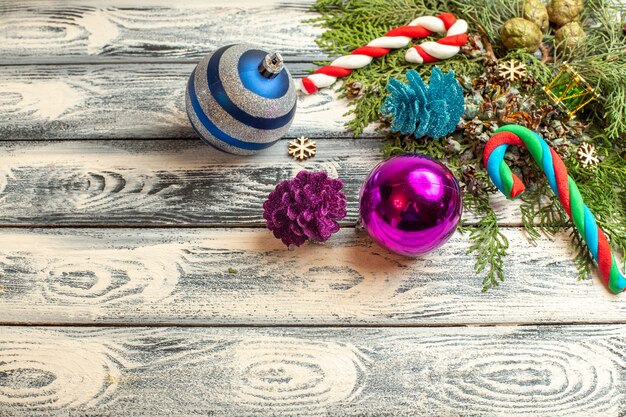 Top view xmas ornnaments gifts candies fir tree branches on wooden surface