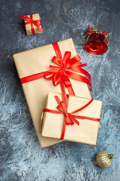 Top view xmas presents tied with red bows on light-dark background