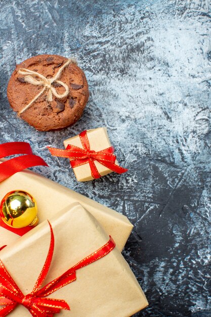 Top view xmas presents with biscuits on light-dark background