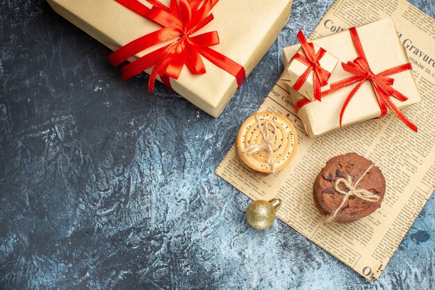 Top view xmas presents with biscuits and toys on a light-dark background