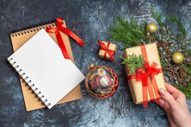 Top view xmas presents with notepad on light-dark background