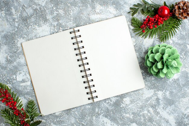 Top view xmas red berry pine cone notepad on grey white table