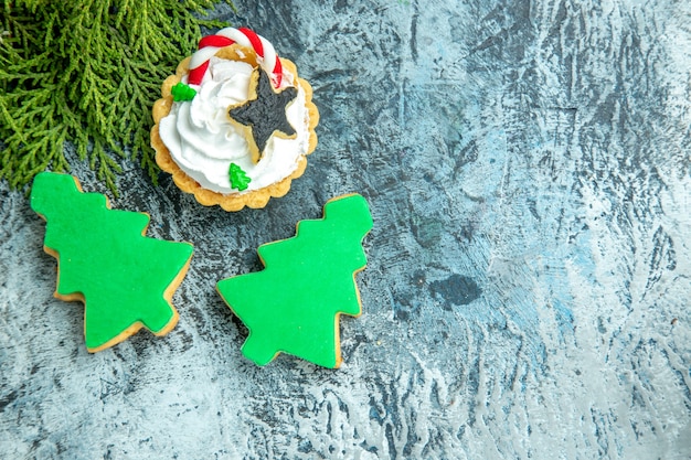 Top view xmas tart pine branch xmas tree biscuits on grey table free place