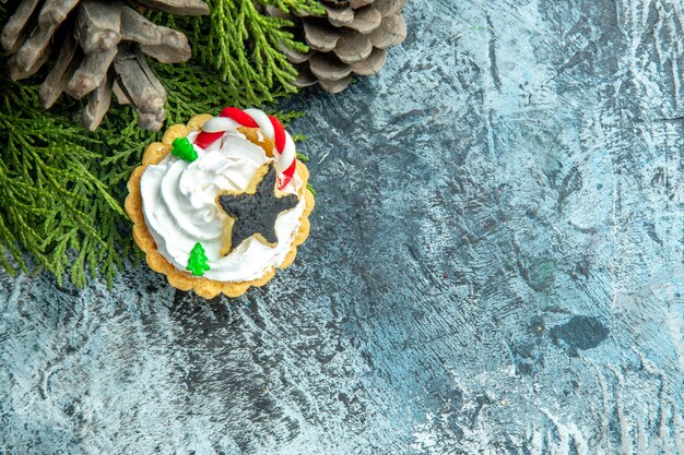 Top view xmas tart pine branches pinecones on grey table with free space