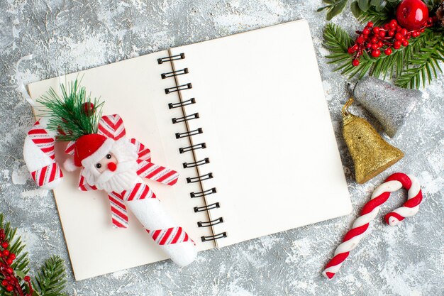 灰色の白いテーブルの上のメモ帳クリスマスツリー飾りの上面図クリスマスおもちゃ