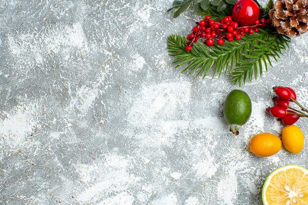 Top view xmas tree branches cut lemons feijoas on grey table with copy place