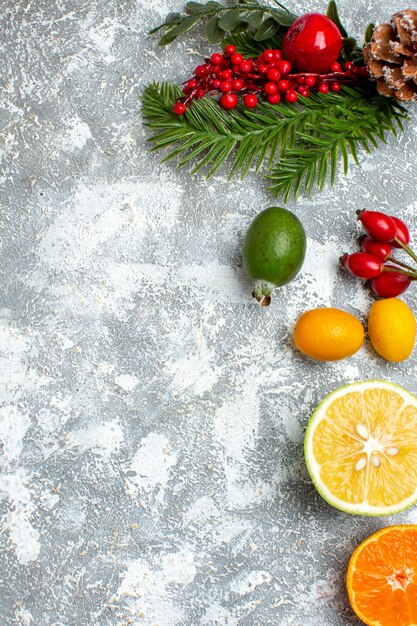 Top view xmas tree branches cut lemons feijoas on grey table with free space
