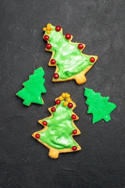 Top view xmas tree cookies on dark isolated surface new year photo