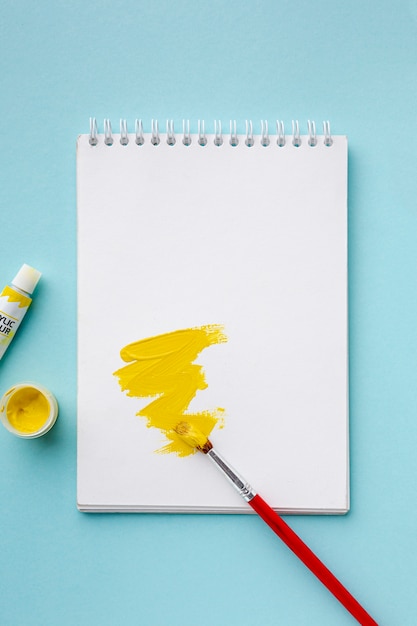 Top view of yellow aquarelle on notebook