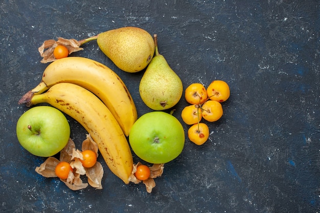 Free photo top view yellow bananas pair of berries with green apples pears on the dark-blue desk fruit berry fresh health vitamine sweet