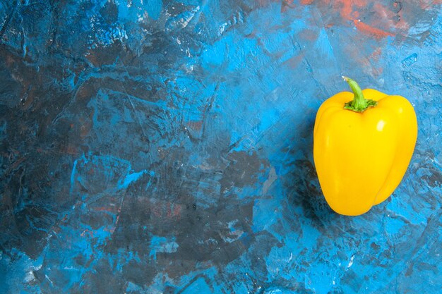 Вид сверху желтого болгарского перца на синей поверхности