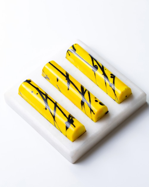 Top view yellow in black speck chocolate candy on white stand