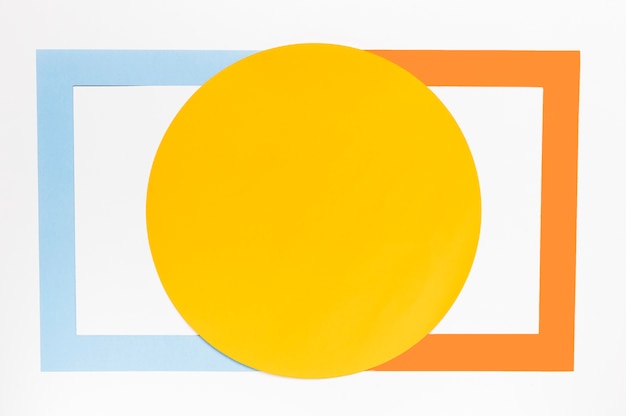 Вид сверху желтый круг с разноцветными геометрическими фигурами