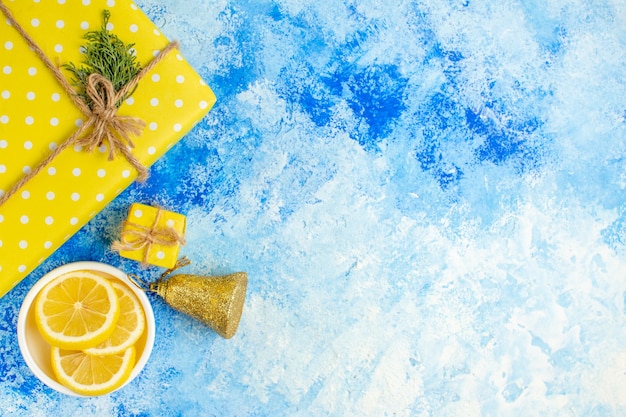 Top view yellow gift lemon slices on blue table free space