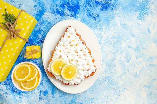 파란색 테이블 여유 공간에 접시에 노란색 선물 레몬 조각 케이크 상위 뷰