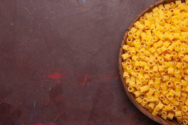 Top view yellow italian pasta raw little formed on dark background pasta food raw dough meal