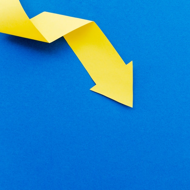 Top view of yellow paper arrow with copy space