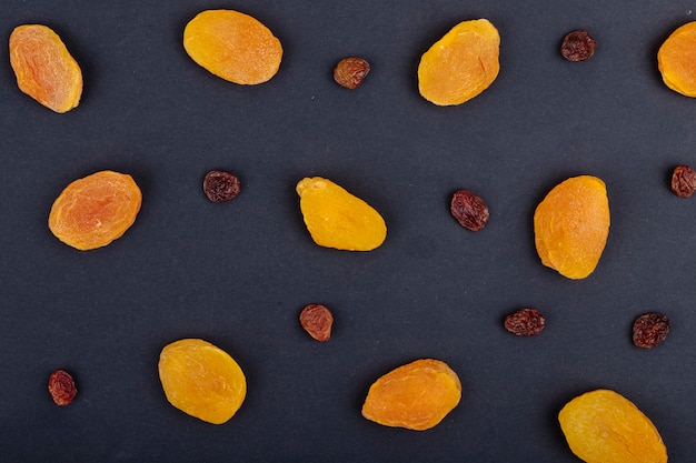 Top view of yellow raisins isolated on black background